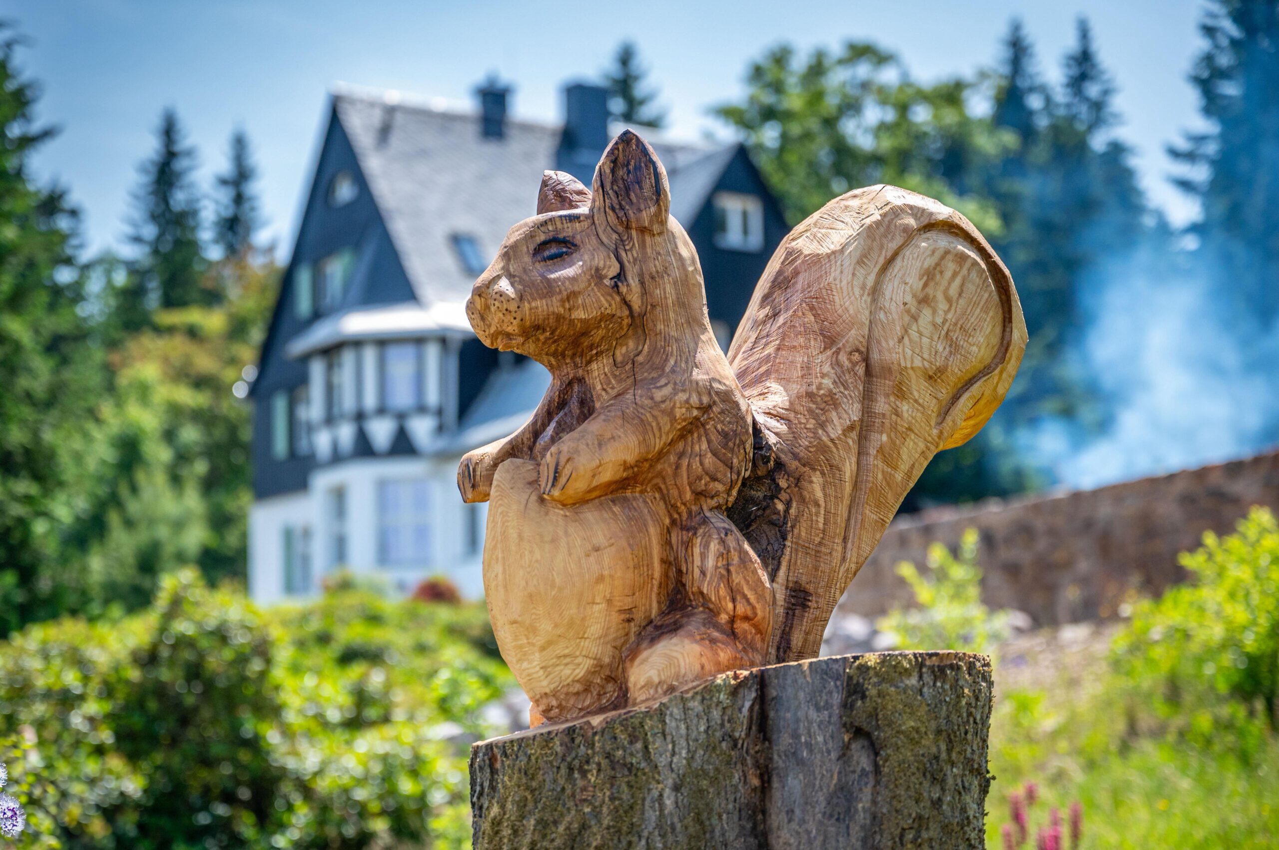 Die handgefertigte Tierskulptur aus massivem Eichenholz unterstreicht die naturnahe Gestaltung der Außenanlagen und fügt sich in das architektonische Gesamtbild der Einrichtung ein.